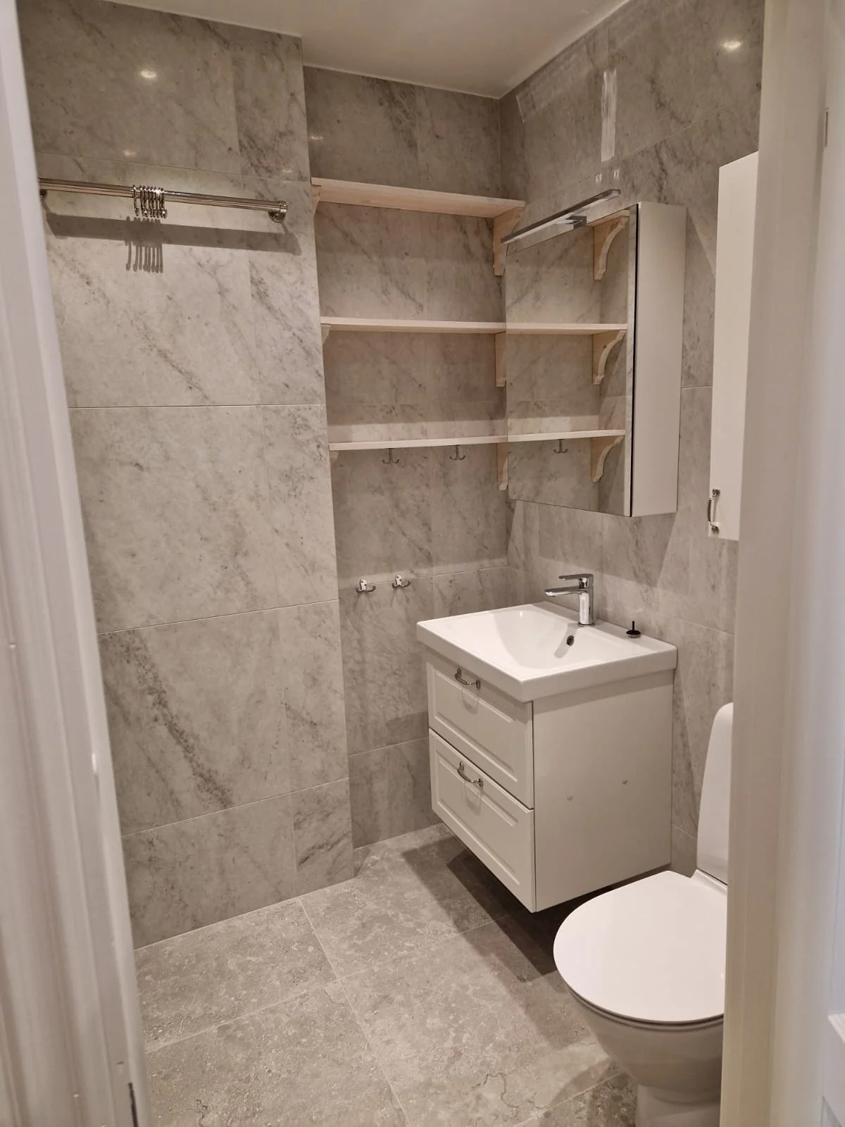 Renoverat badrum med ekkommod och rund spegel